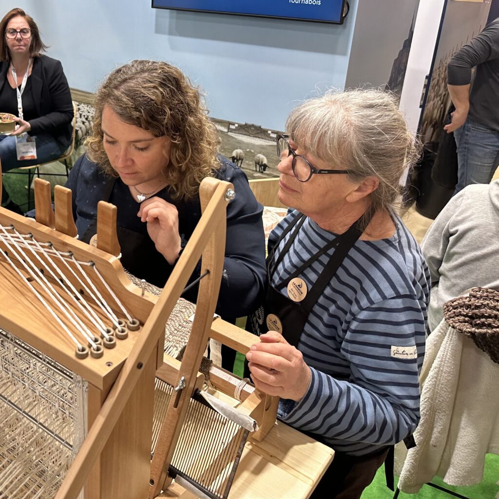 Deux femmes travaillent sur un métier à tisser, explorant la technique de tissage de la laine.
