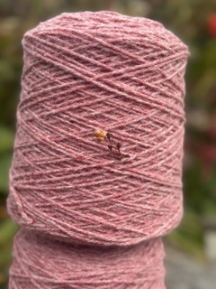 Fil de laine pure teinte rose, provenant de moutons normands, symbole de l'artisanat local et durable.