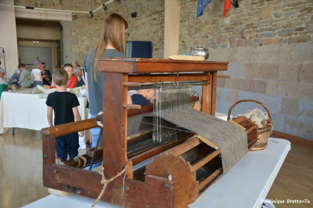 Métier à tisser en bois avec de la laine en cours de transformation, lors d'un atelier de Laines sous les Pommiers.