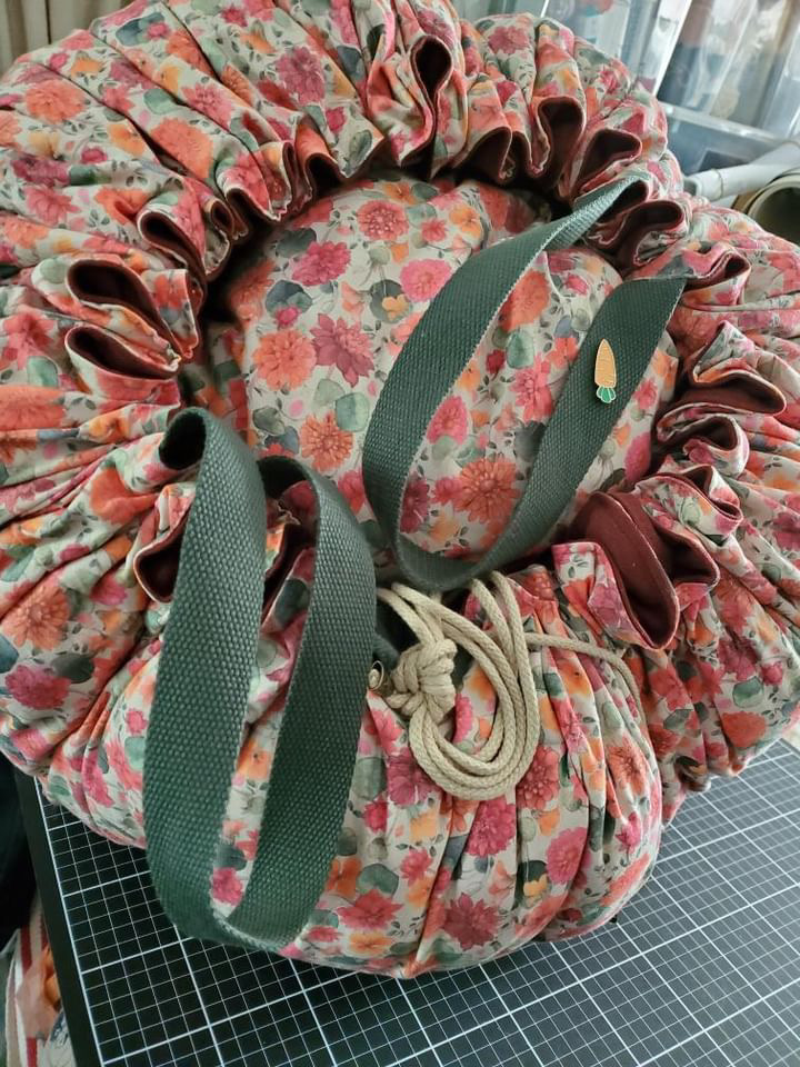 Sac en tissu fleuri avec des anses vertes, fabriqué par Laines sous les Pommiers, mettant l'accent sur la durabilité.