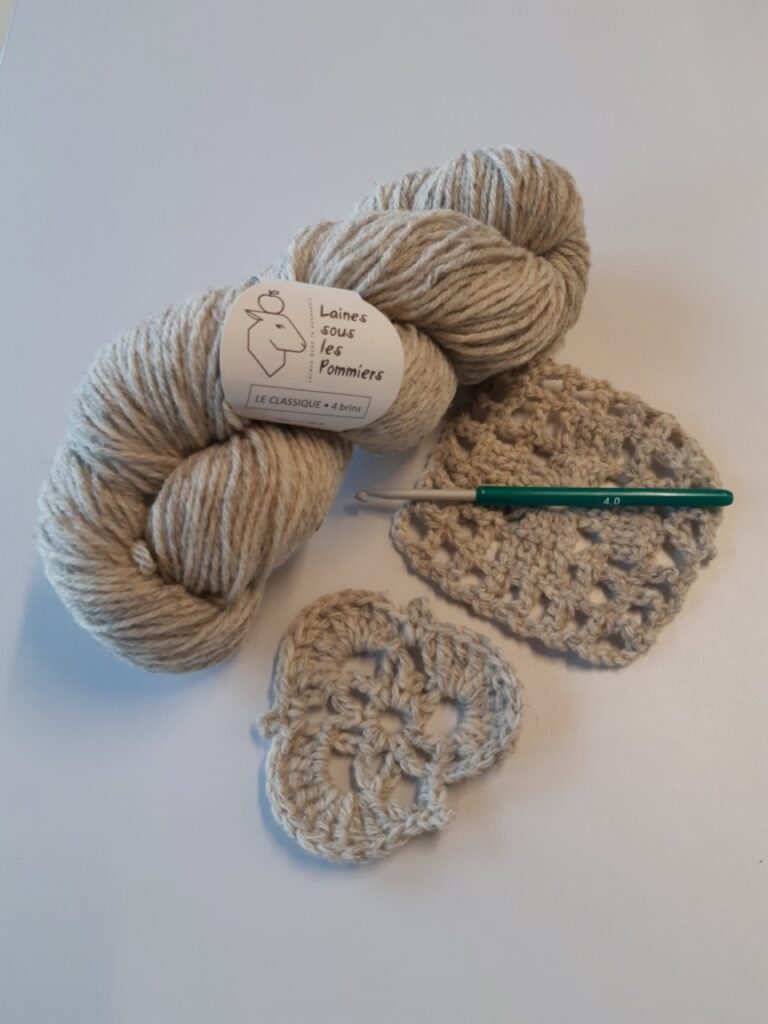 Pelote de laine naturelle de Laines sous les Pommiers, avec échantillons tricotés et un crochet. Artisanat durable.