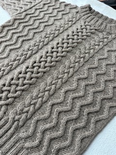 Pull en laine pure normande, tricoté avec motifs en relief, mettant en valeur l'artisanat local.